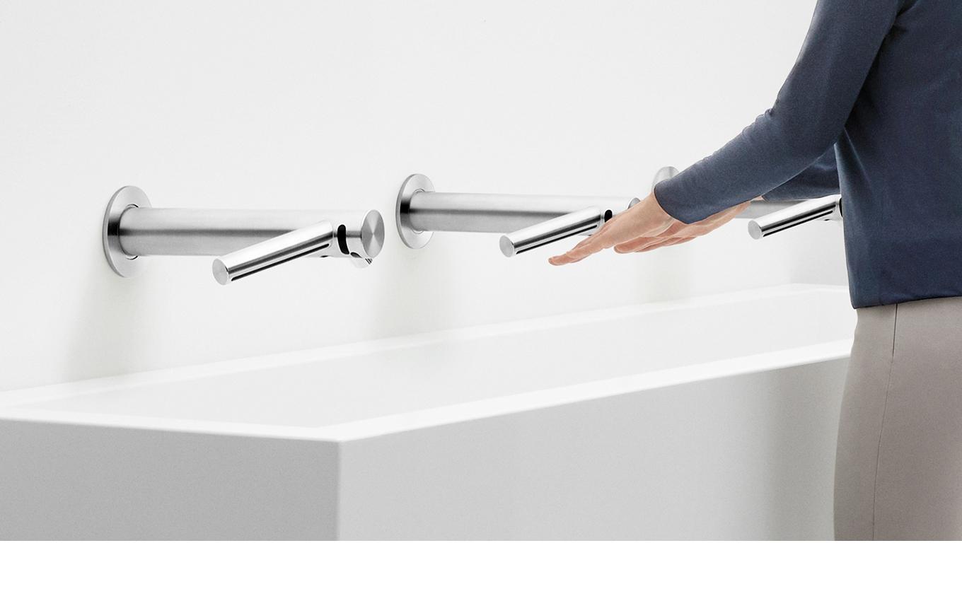 Washing hands underneath the Dyson Airblade™ Wash+Dry hand dryer